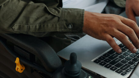Man With Disability Typing On Laptop